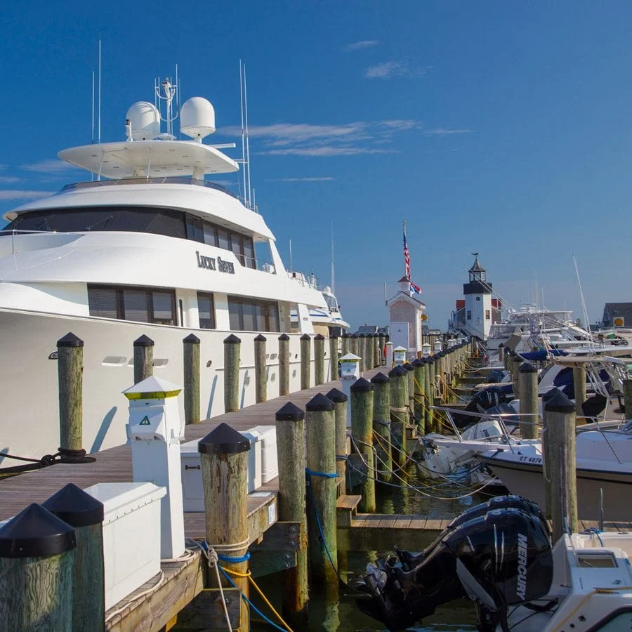 Yacht parked in Saybrook Point Resort & Marina marina with smaller boats parked on the other side of the dock.