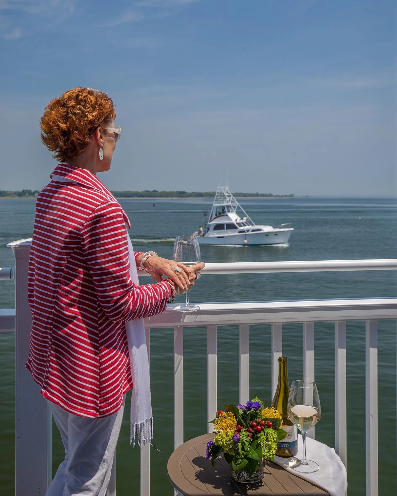 OIder Red Haired Women On Balcony Looking At Boats On The Connecticut River