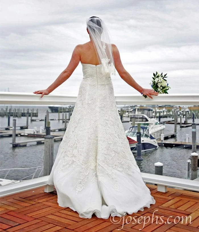 Bride looking out on harbor.