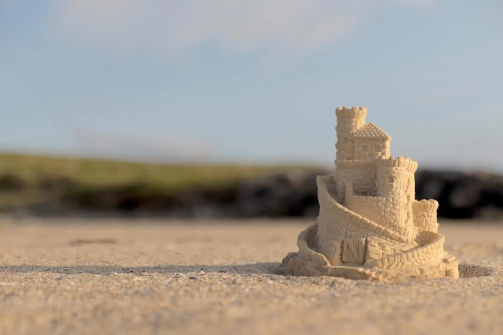 A sandcastle sits on the serene shores of Harvey's Beach.